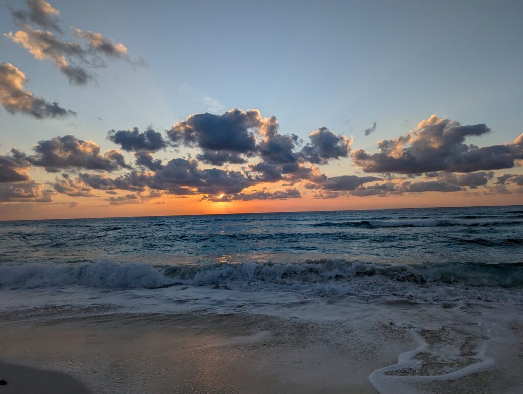 tropical beach wit waves at sunset